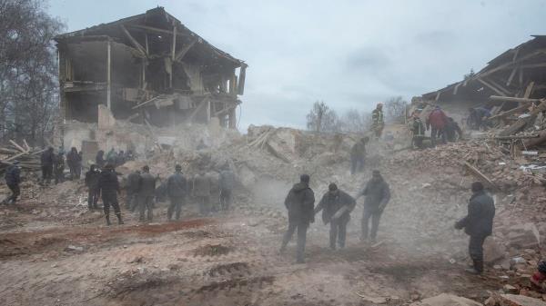 People remove debris at the site of a military ba<em></em>se building that, according to the Ukrainian ground forces, was destroyed by an air strike, in the town of Okhtyrka in the Sumy region, Ukraine, on February 28, 2022. (Reuters)