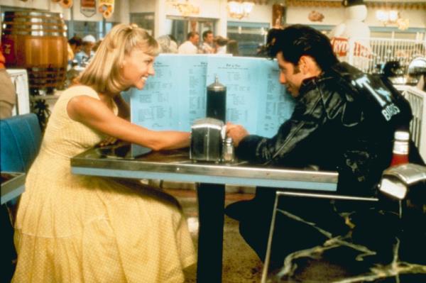 Olivia Newton-John and John Travolta sitting at a table